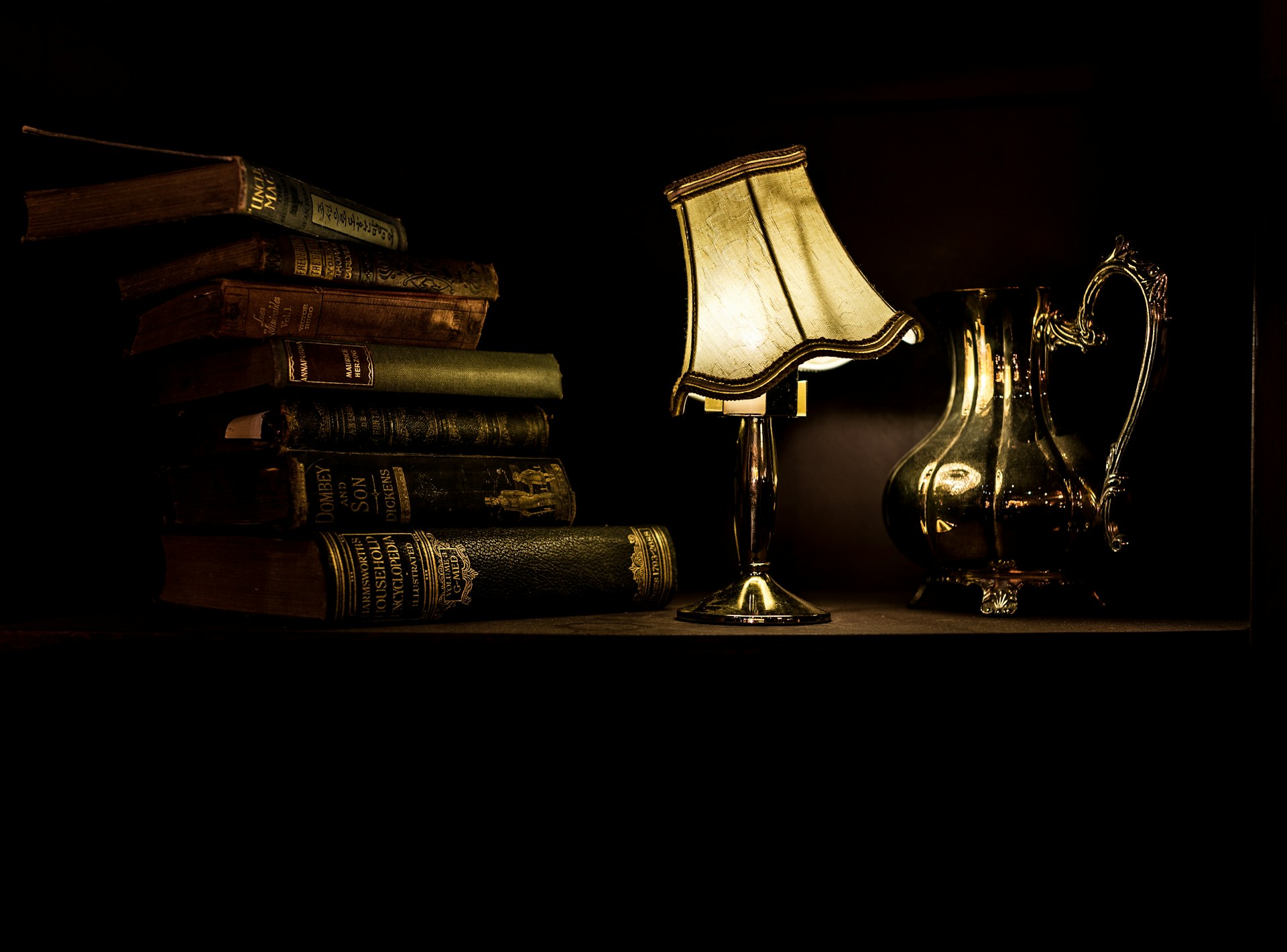 Warm lamplight falling across a shelf of books
